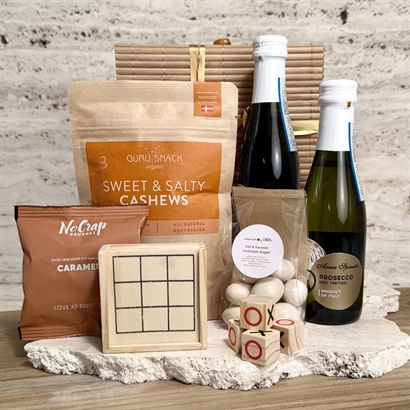 Hygge firmagave med spil, prosecco, chokolademandler og Snacks.