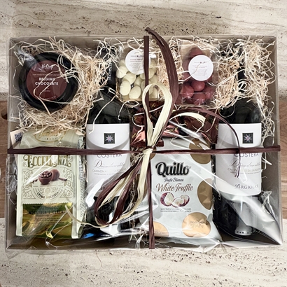 Eksklusiv sardiske rødvine med snacks og chokolade i gavekurv med cellofan